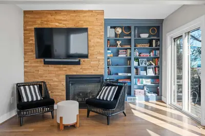 a living room with two chairs and a fireplace at Next to Monastery Wedding Venue, 2BR with Balcony in Cincinnati
