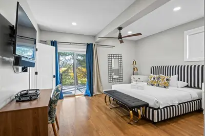 a bedroom with a king sized bed and a tv at Next to Monastery Wedding Venue, 2BR with Balcony in Cincinnati