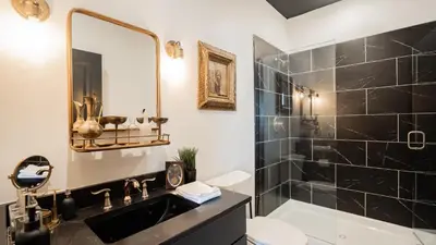 a bathroom with a sink and a shower with a mirror at Pickle Factory Hotel - 2BR Next to Wenzel Distillery in Covington