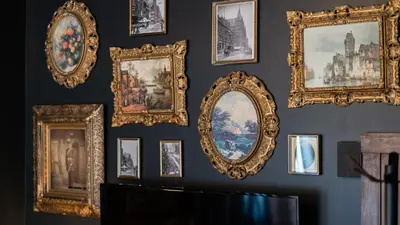 a wall full of framed mirrors on a wall at Pickle Factory Hotel - 2BR Next to Wenzel Distillery in Covington