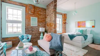 a bedroom with a bed and a couch in a room at Pickle Factory Hotel - 1BR Historic Downtown with Parking in Covington