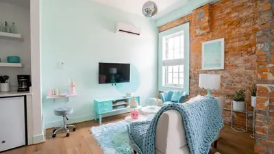 a living room with a couch and a brick wall at Pickle Factory Hotel - 1BR Historic Downtown with Parking in Covington