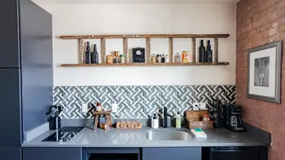 a kitchen with a sink and a brick wall at Pickle Factory Hotel - 1BR Close to Stadiums & Bars in Covington