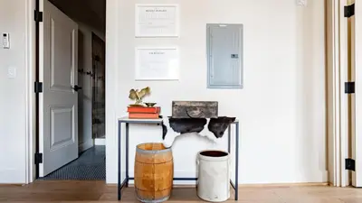 a hallway with a table and a stool at Pickle Factory Hotel - 1BR Close to Stadiums & Bars in Covington