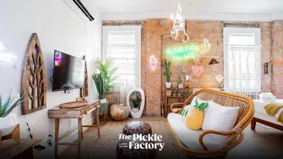 a living room with a couch and a tv at Pickle Factory Hotel - 1BR Near Bars & Restaurants in Covington