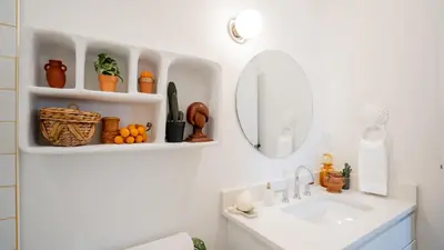 a bathroom with a sink and a mirror at Pickle Factory Hotel - 1BR Near Bars & Restaurants in Covington