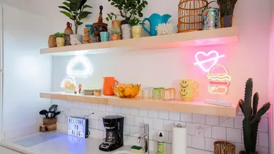 a kitchen with pink shelves above a sink at Pickle Factory Hotel - 1BR Near Bars & Restaurants in Covington