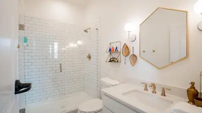 a white bathroom with a tub and a sink at Pickle Factory Hotel - 1BR Beside New Distillery! in Covington