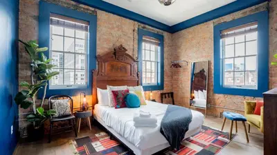 a bedroom with blue walls and a large bed at Pickle Factory Hotel - 1BR Beside New Distillery! in Covington