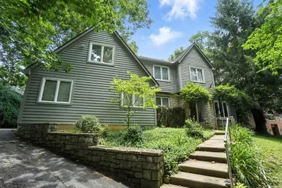 a gray house with a stone retaining wall in front of it at 10 Mi to Dtwn Cozy Couples Getaway in Cincinnati in Cincinnati