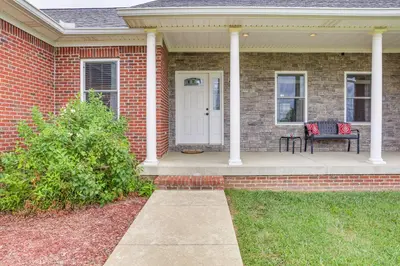 a brick house with a porch with a bench on it at 14 Mi to Ark Encounter Rural Corinth Escape! in Corinth