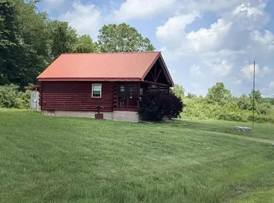 a barn with a red roof in a field at Fisherman’s Dream in McArthur