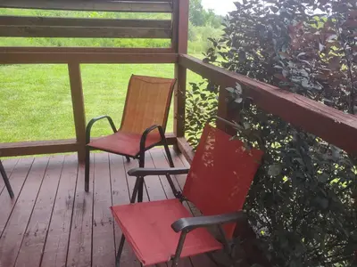 two chairs sitting on a porch with an apple tree at Fisherman’s Dream in McArthur