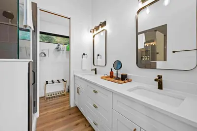 a white bathroom with a sink and a mirror at Lakefront Home with Dock - Hot tub - 7 miles to Ark in Williamstown