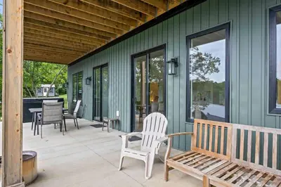 a porch with chairs and a bench on a house at Lakefront Home with Dock - Hot tub - 7 miles to Ark in Williamstown