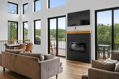a living room with couches and a tv and a fireplace at Lakefront Home with Dock - Hot tub - 7 miles to Ark in Williamstown