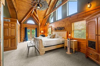 a bedroom with a bed in a wooden room at Lakeside Log Home, Private Dock, Near Ark! in Dry Ridge