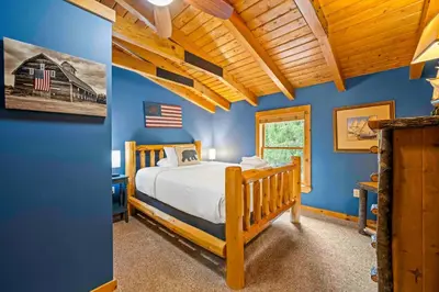 a bedroom with a bed and a blue wall at Lakeside Log Home, Private Dock, Near Ark! in Dry Ridge