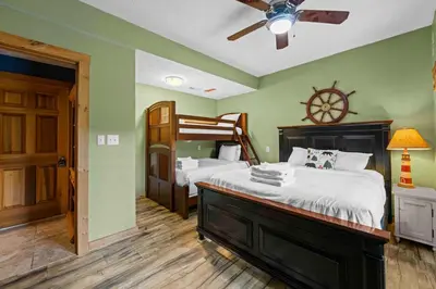 a bedroom with two beds and a ceiling fan at Lakeside Log Home, Private Dock, Near Ark! in Dry Ridge