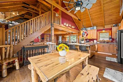a dining room with a wooden table and a kitchen at Lakeside Log Home, Private Dock, Near Ark! in Dry Ridge