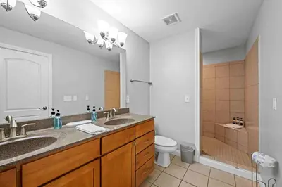 a bathroom with two sinks and a toilet and a mirror at Hilltop 3BR for 10, Private Garage, Skyline Views in Covington