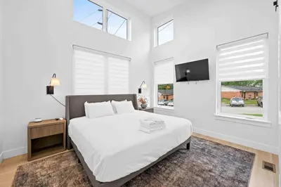 a white bedroom with a bed and a flat screen tv at Hot Tub, 3BR for 10, Near Ark, Private Parking in Dry Ridge