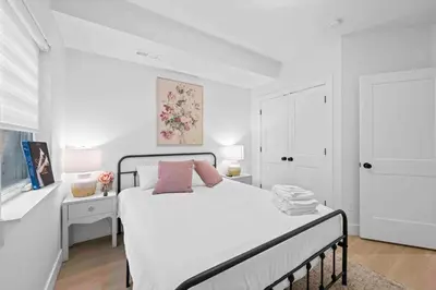 a white bedroom with a white bed with pink pillows at Hot Tub, 3BR for 10, Near Ark, Private Parking in Dry Ridge