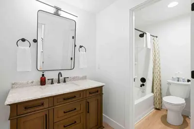 a bathroom with a sink and a toilet and a mirror at 3 Homes, 3 Hot Tubs, 10BR, 10 Bath, Near Ark! in Dry Ridge
