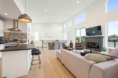 a living room and kitchen with a couch and a table at 3 Homes, 3 Hot Tubs, 10BR, 10 Bath, Near Ark! in Dry Ridge