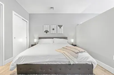 a white bedroom with a large bed and white walls at Modern DT Stay, King Bed, Parking Available in Cleveland