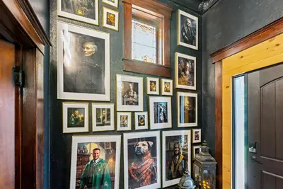 a bunch of pictures on a wall in a room at School of Sorcery in Brinkhaven