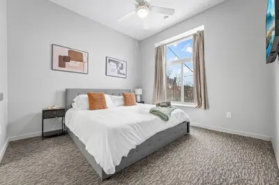 a white bedroom with a bed and a window at Cozy 2BR Getaway, King Bed, Free Parking in Cleveland