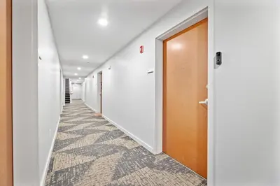 a hallway with white walls and a brown door at Cozy 2BR Getaway, King Bed, Free Parking in Cleveland