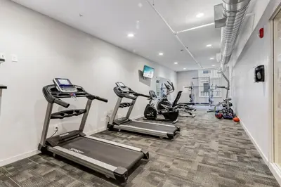 a gym with treadmills and ellipticals in a room at Cozy 2BR Getaway, King Bed, Free Parking in Cleveland