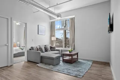a white living room with a couch and a table at Cozy 2BR Getaway, King Bed, Free Parking in Cleveland