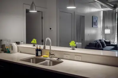 a kitchen with a sink and a large mirror at Cozy 2BR Getaway, King Bed, Free Parking in Cleveland