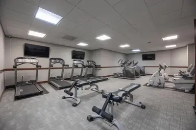 a gym with several treadmills and exercise bikes at 1BR Retreat, 2 Smart TVs, WiFi & Free Parking in Cleveland