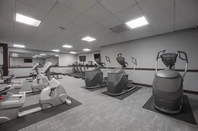 a gym with treadmills and machines in a room at 1BR Retreat, 2 Smart TVs, WiFi & Free Parking in Cleveland