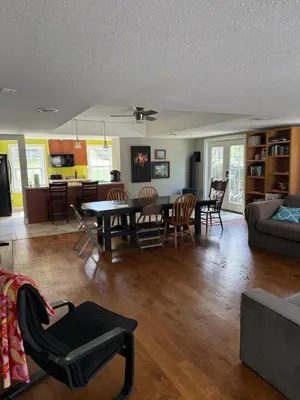 a living room with a table and a dining room at Old Orchard