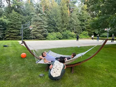 three people sitting in a hammock in a park at Old Orchard