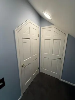two white doors in a room with blue walls at Old Orchard