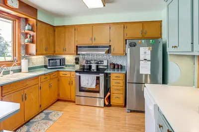 a kitchen with wooden cabinets and stainless steel appliances at Less Than 1 Mi to Dtwn Tiffin Home with Outdoor Space! in Tiffin