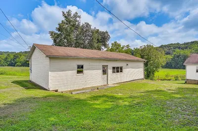a white building in the middle of a field at 4 Mi to Ohio River Quiet Guest House with Yard!