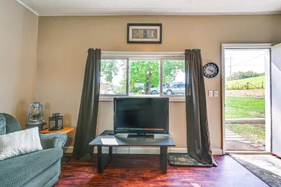 a living room with a tv and a couch and a table at 4 Mi to Ohio River Quiet Guest House with Yard!