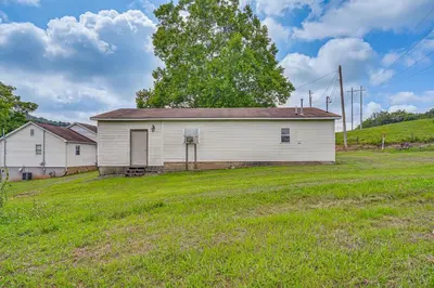 an old white building in a grassy field at 4 Mi to Ohio River Quiet Guest House with Yard!