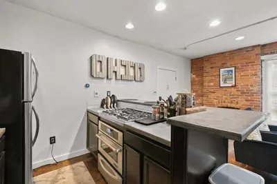 a kitchen with a stove top oven next to a refrigerator at Short North Lounge - Stay for 2 in Columbus