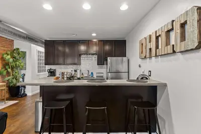 a kitchen with a large island with bar stools at Short North Lounge - Stay for 2 in Columbus