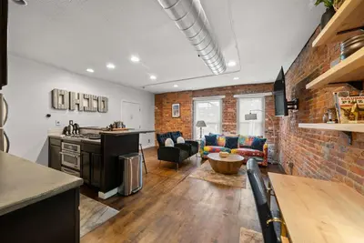 a kitchen and living room with a brick wall at Short North Lounge - Stay for 2 in Columbus