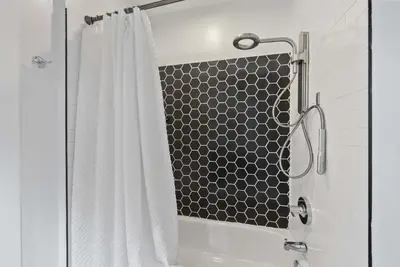 a shower with a black and white shower curtain at Short North Lounge - Stay for 2 in Columbus