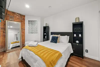 a bedroom with a large bed and a mirror at Short North Lounge - Stay for 2 in Columbus